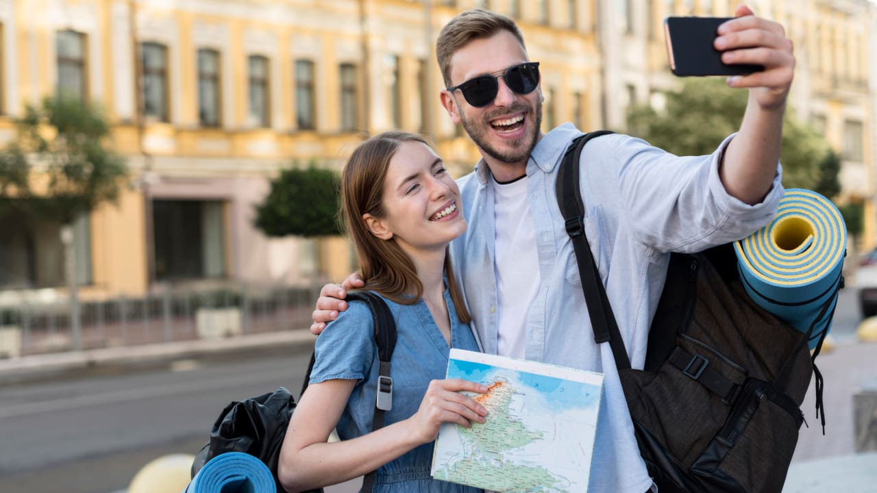 A couple taking selfie while carrying a backpack