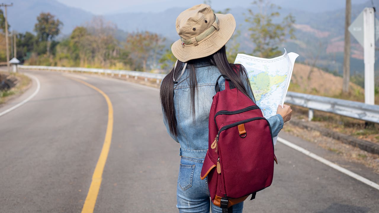 A girl searching right direction on a map