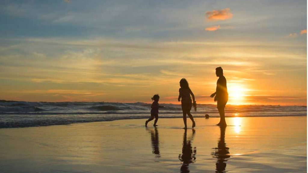 family playing together at the beach