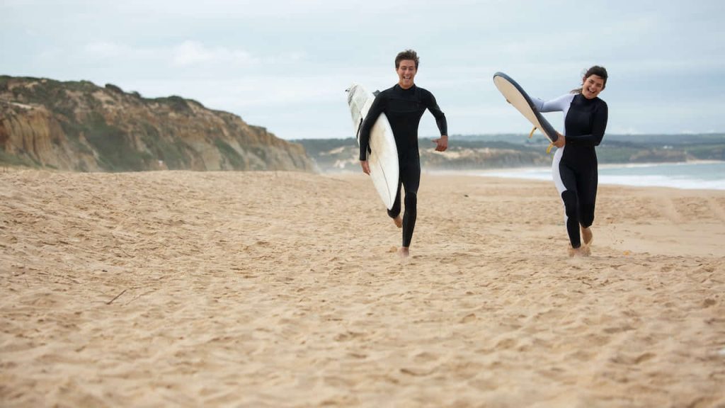 Couple running on the beach, ready for an adventure