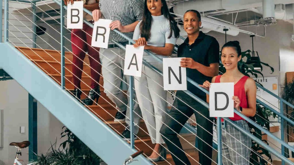 people holding BRAND boards