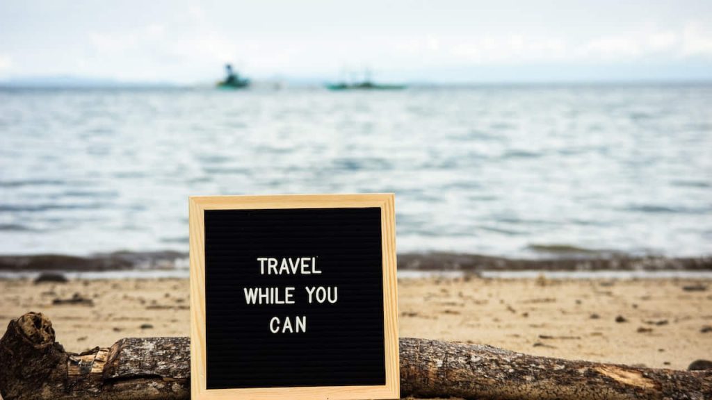 motivational quote board on a beach