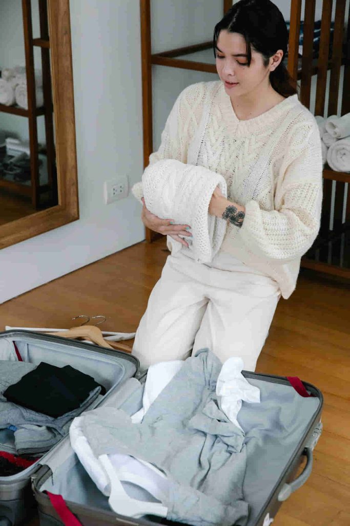 woman packing clothes in luggage