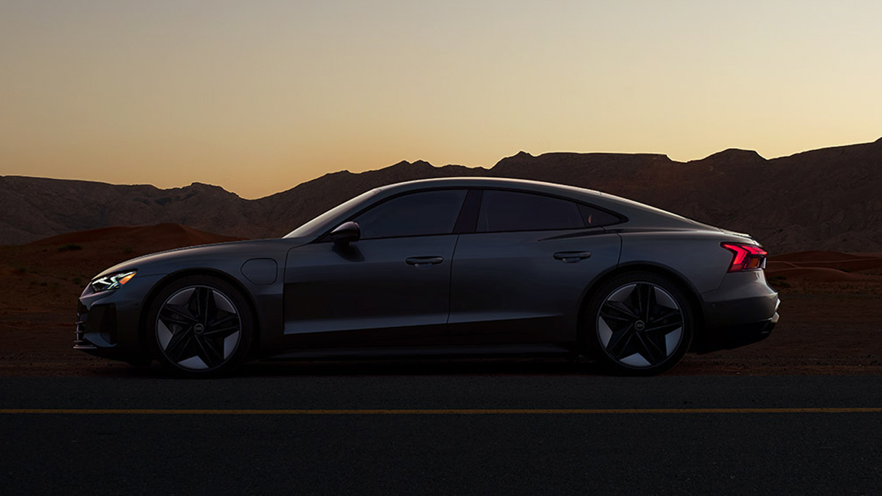 Audi RS e‑tron GT is parked on highway at dawn