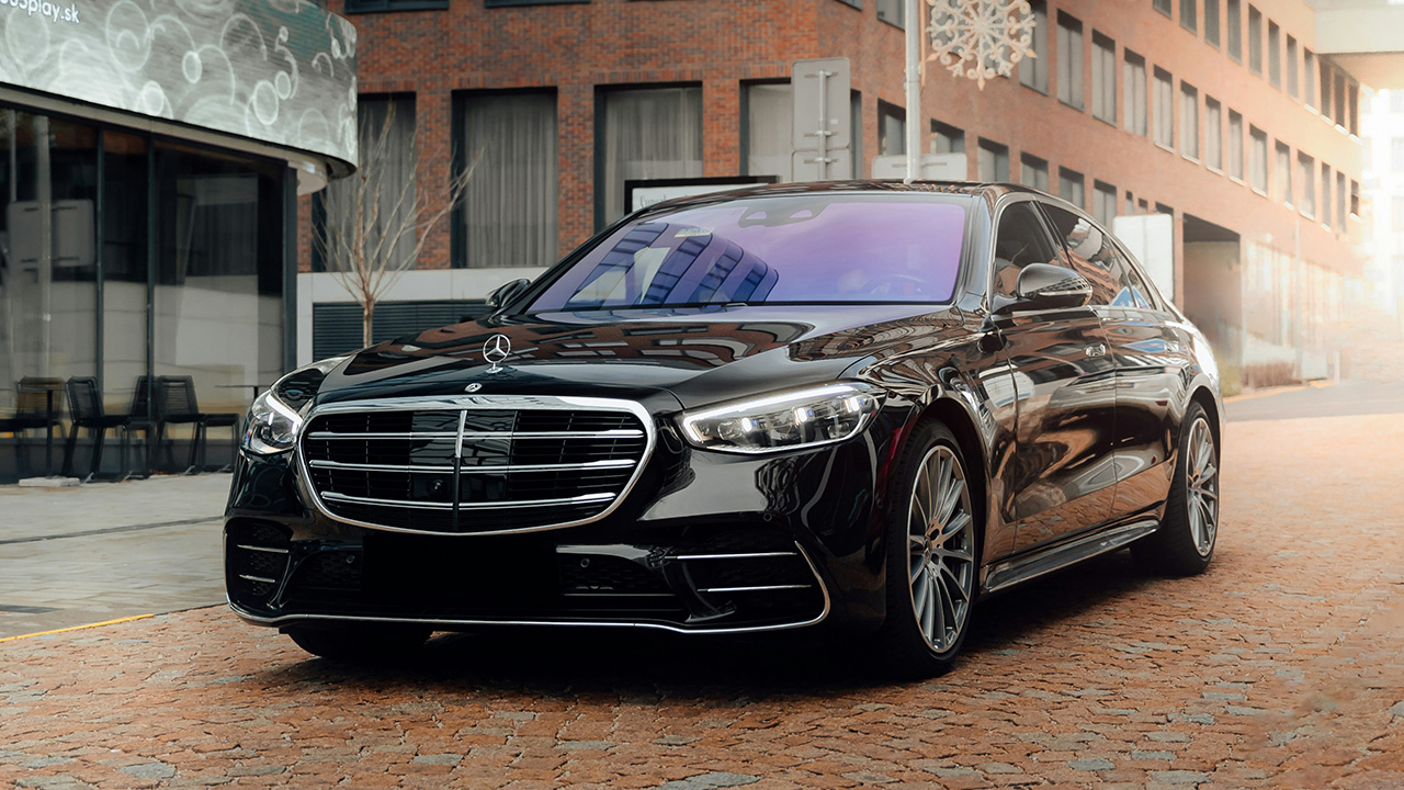 jet black Mercedes Benz SL in standing ahead of a building and café