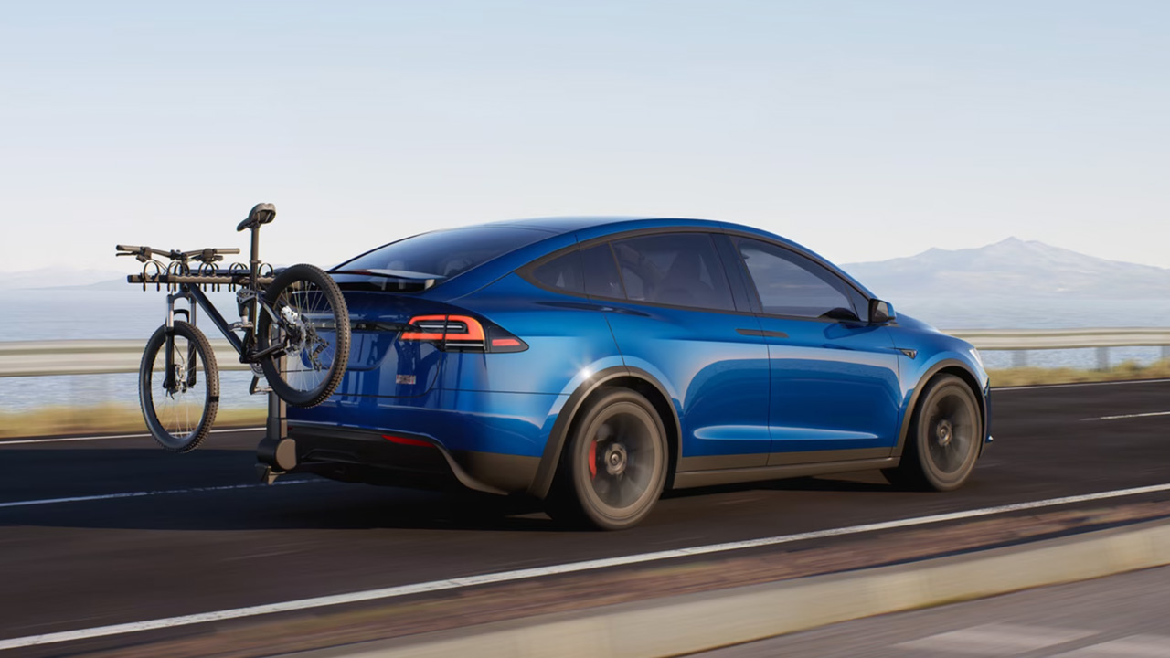 a mini bicycle is hanging from the Tesla Model X