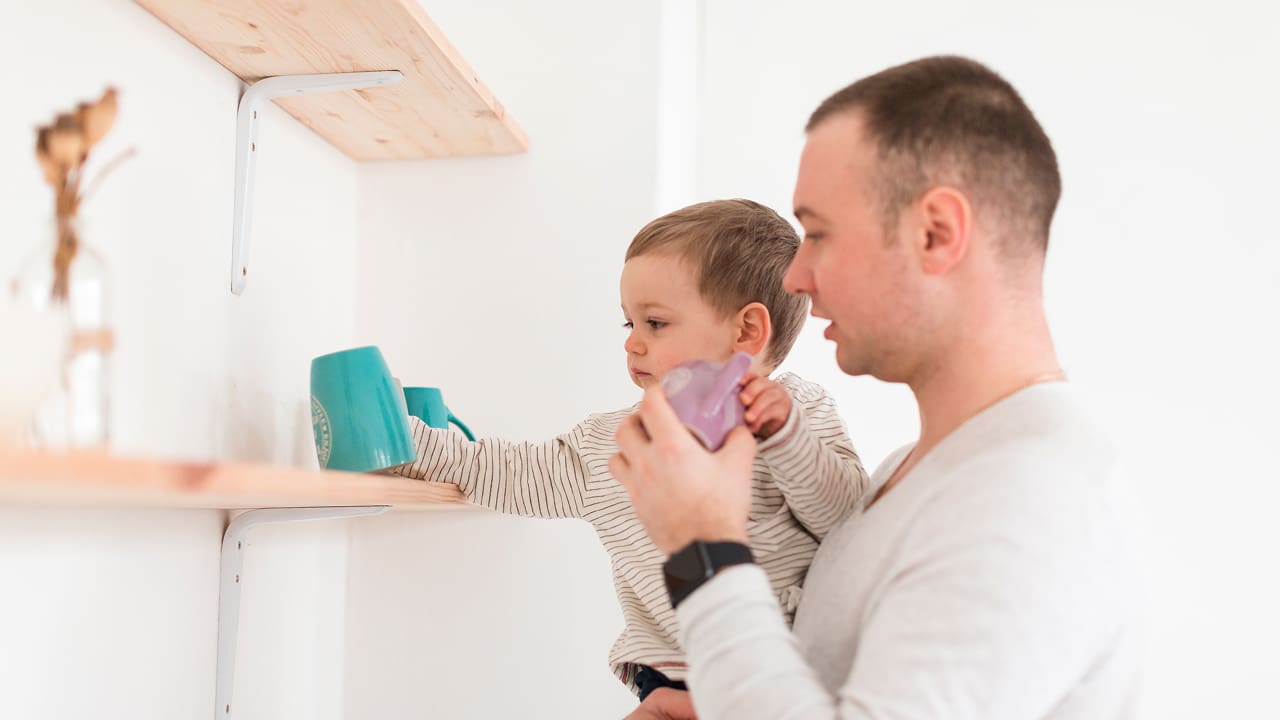 Side view of a father holding a child
