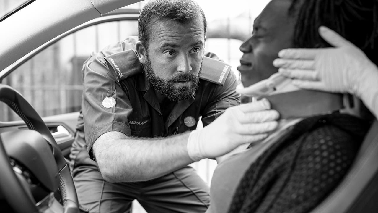 A man is placing a collar on an injured woman.