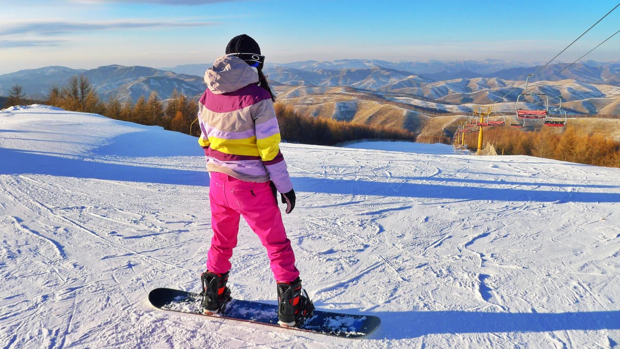 A girl is standing on a snowboard