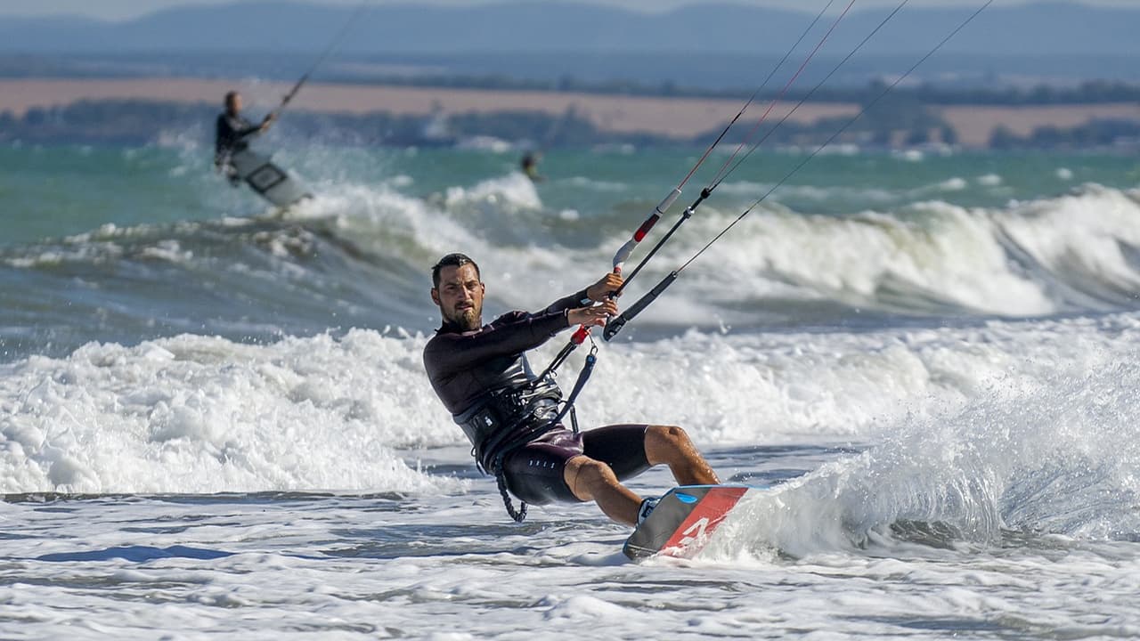 A man doing kiteboarding, which is considered an extreme sport
