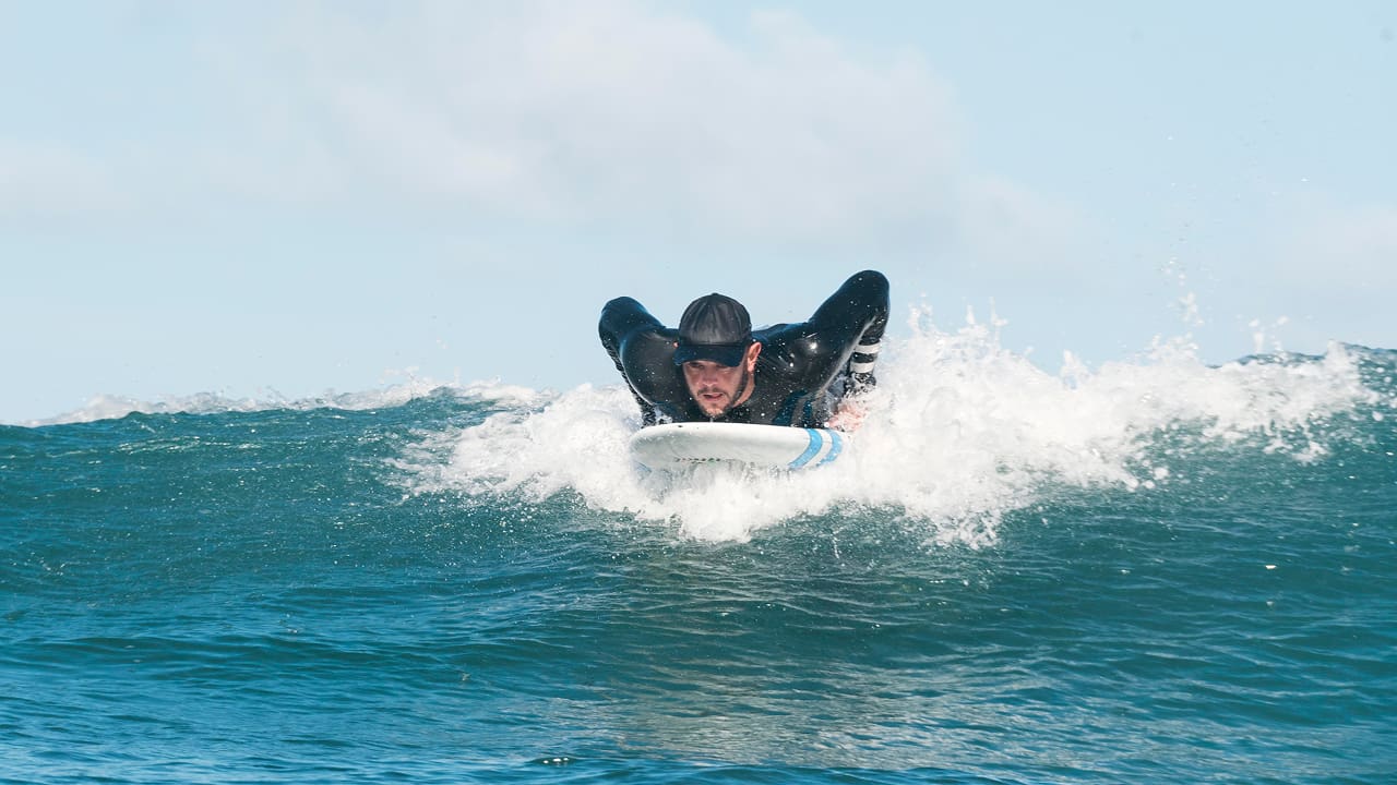 Sporty man surfing in water