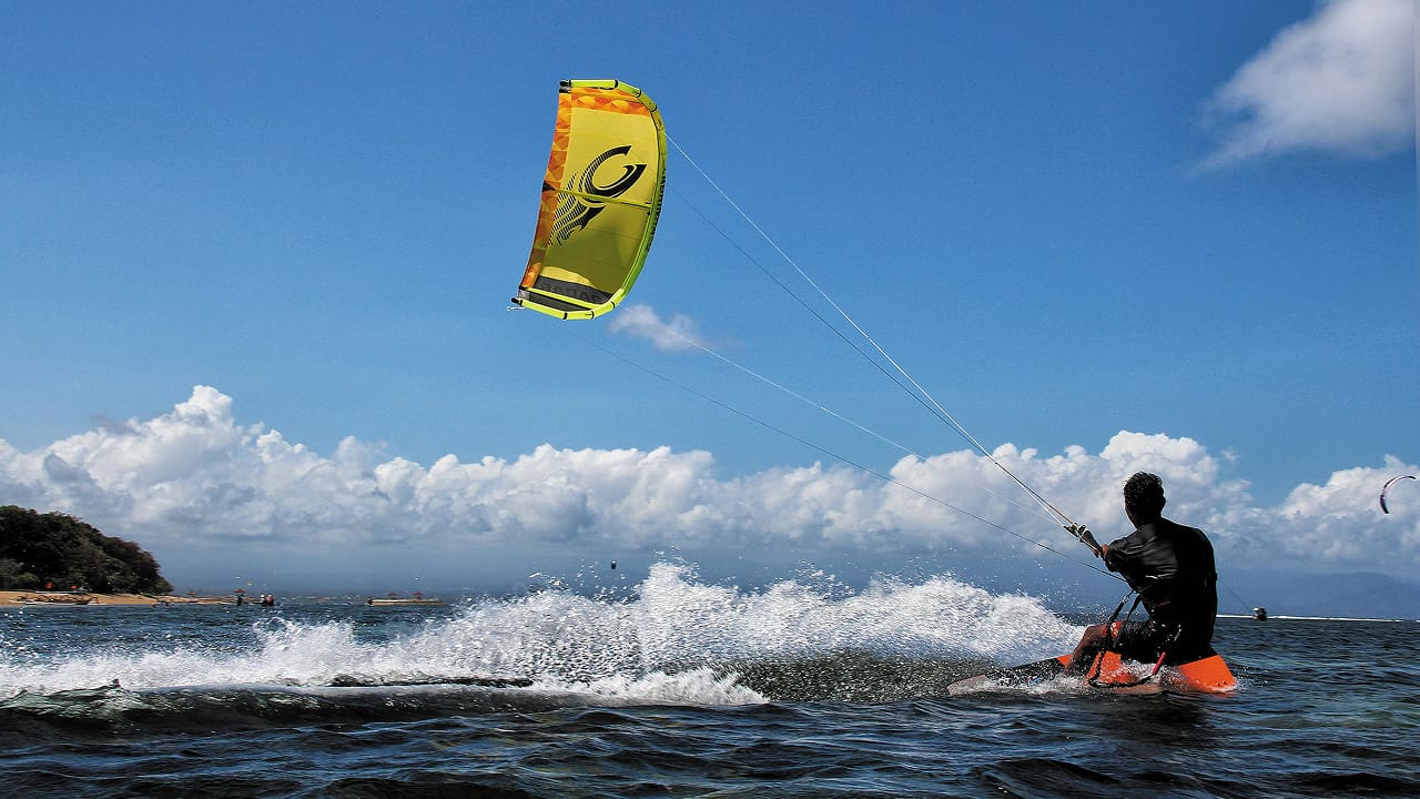 A boy in the sea and holding a kite
