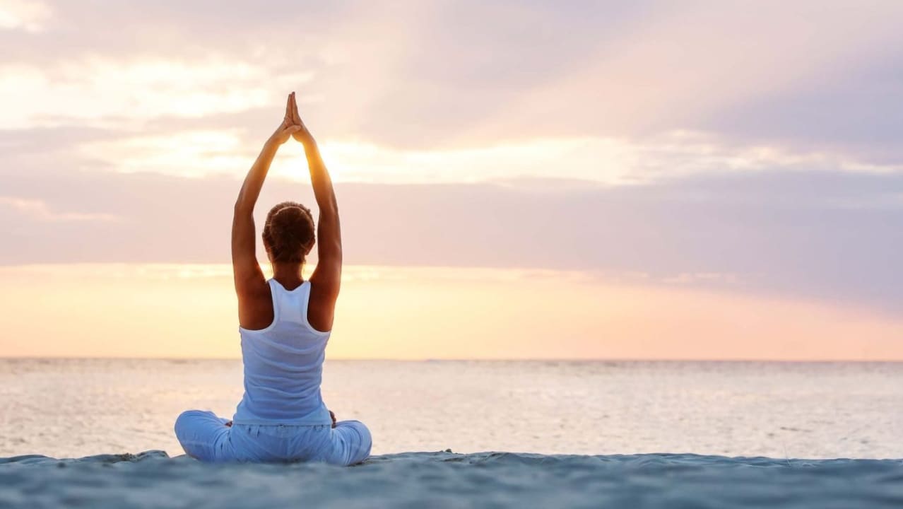 A women doing yoga on a beachside