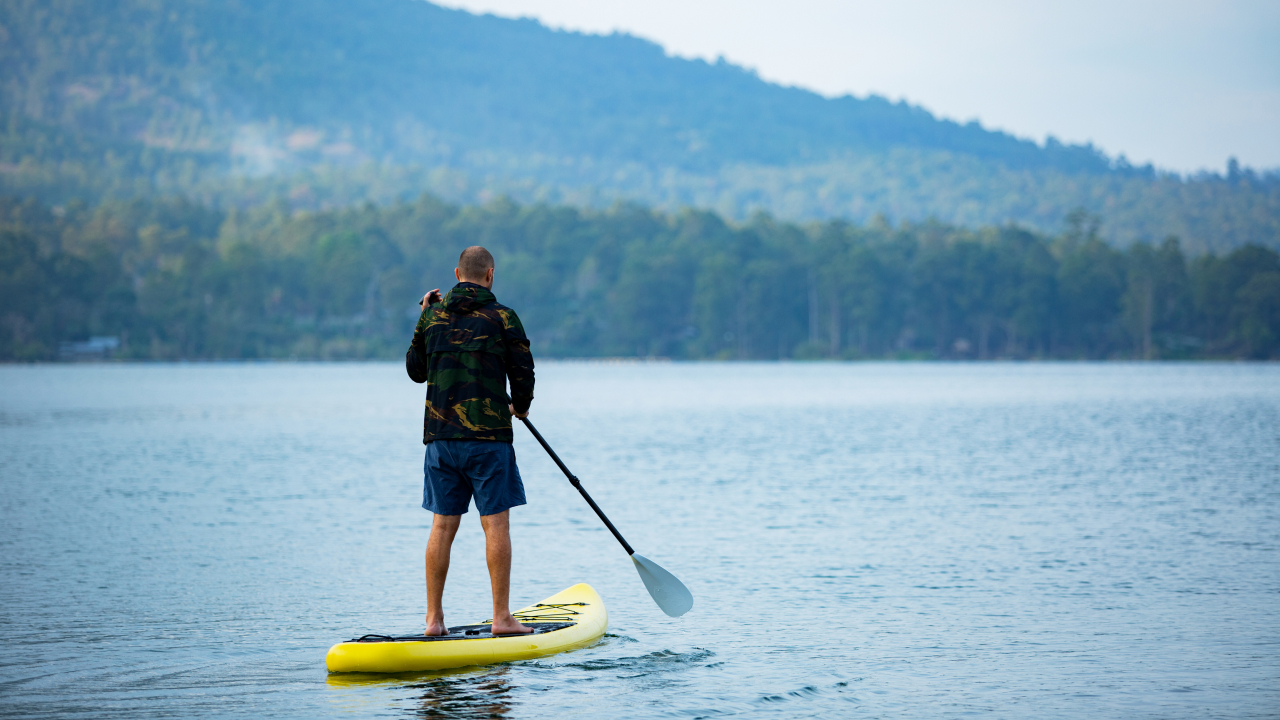 A man on the lake standing on a board