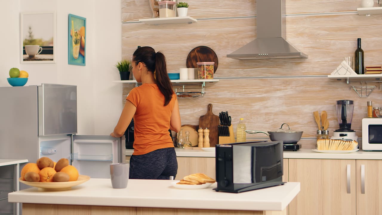 Women taking out something from fridge in the morning