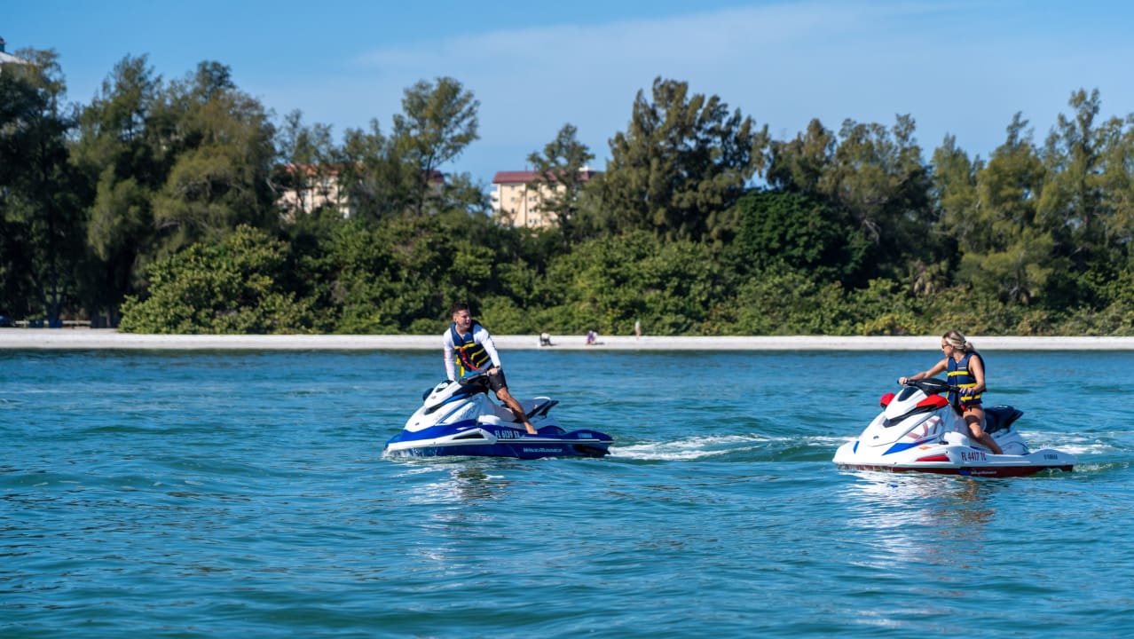 A man and a woman are riding a jet ski at Siesta Beach
