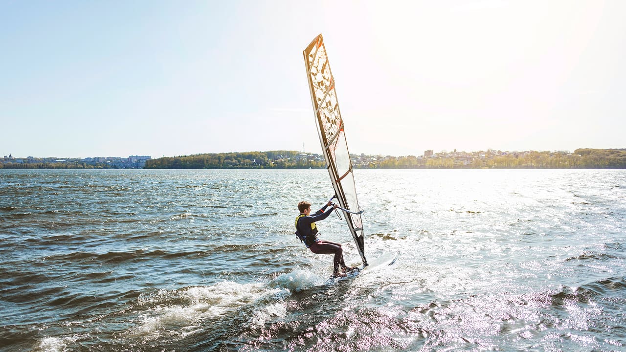 Young man holding a kitesurf board
