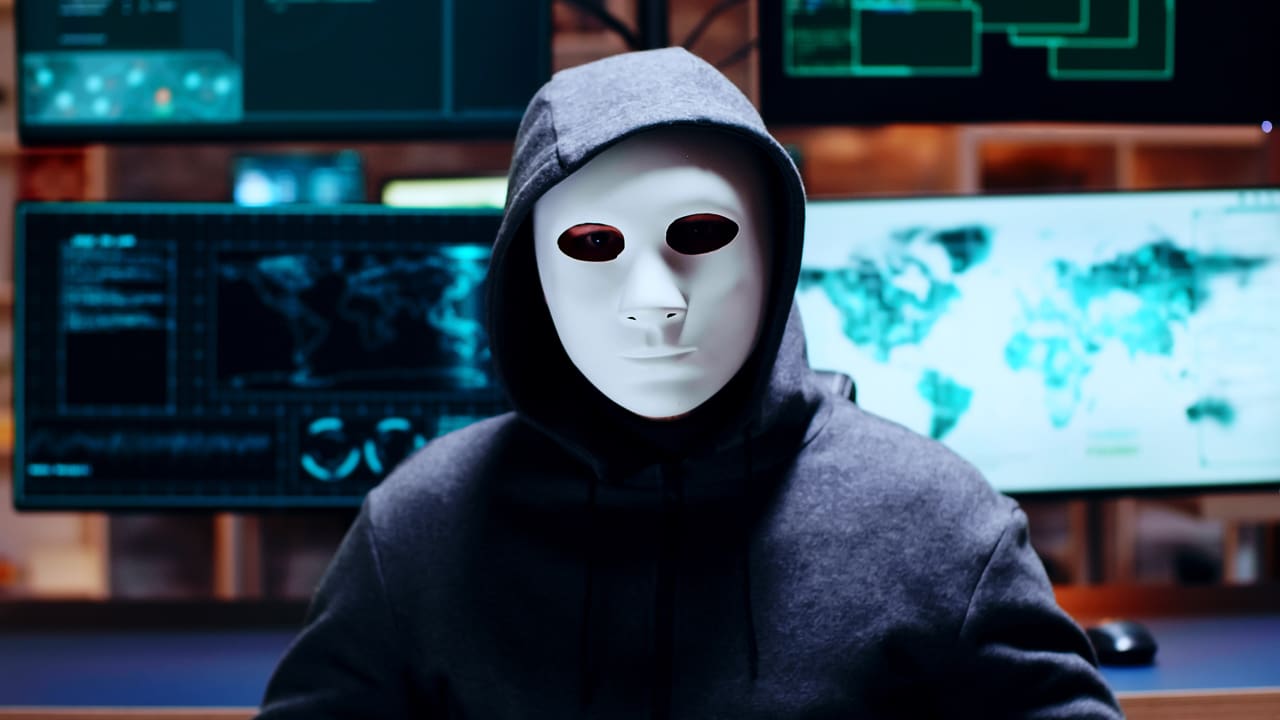 A man wearing a white mask and looking at a camera