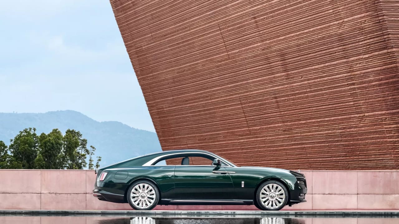 Rolls-Royce is standing in front of a red brick wall
