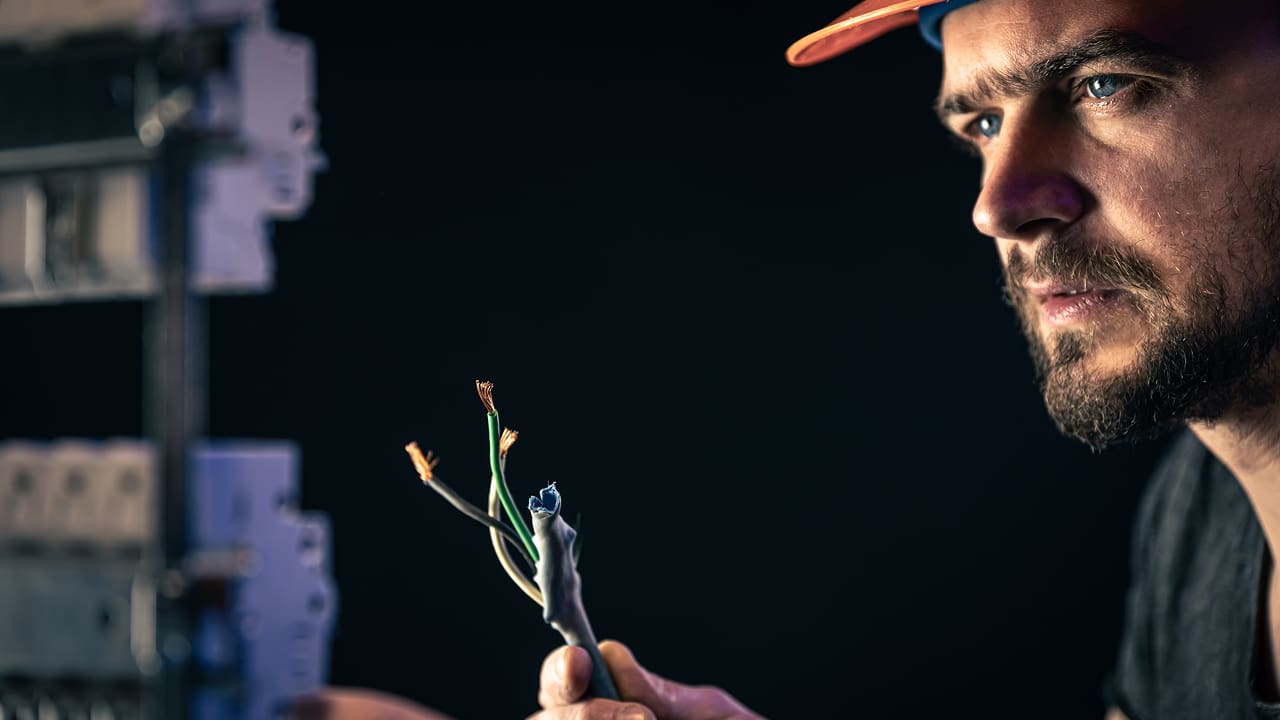 A male electrician working with cables