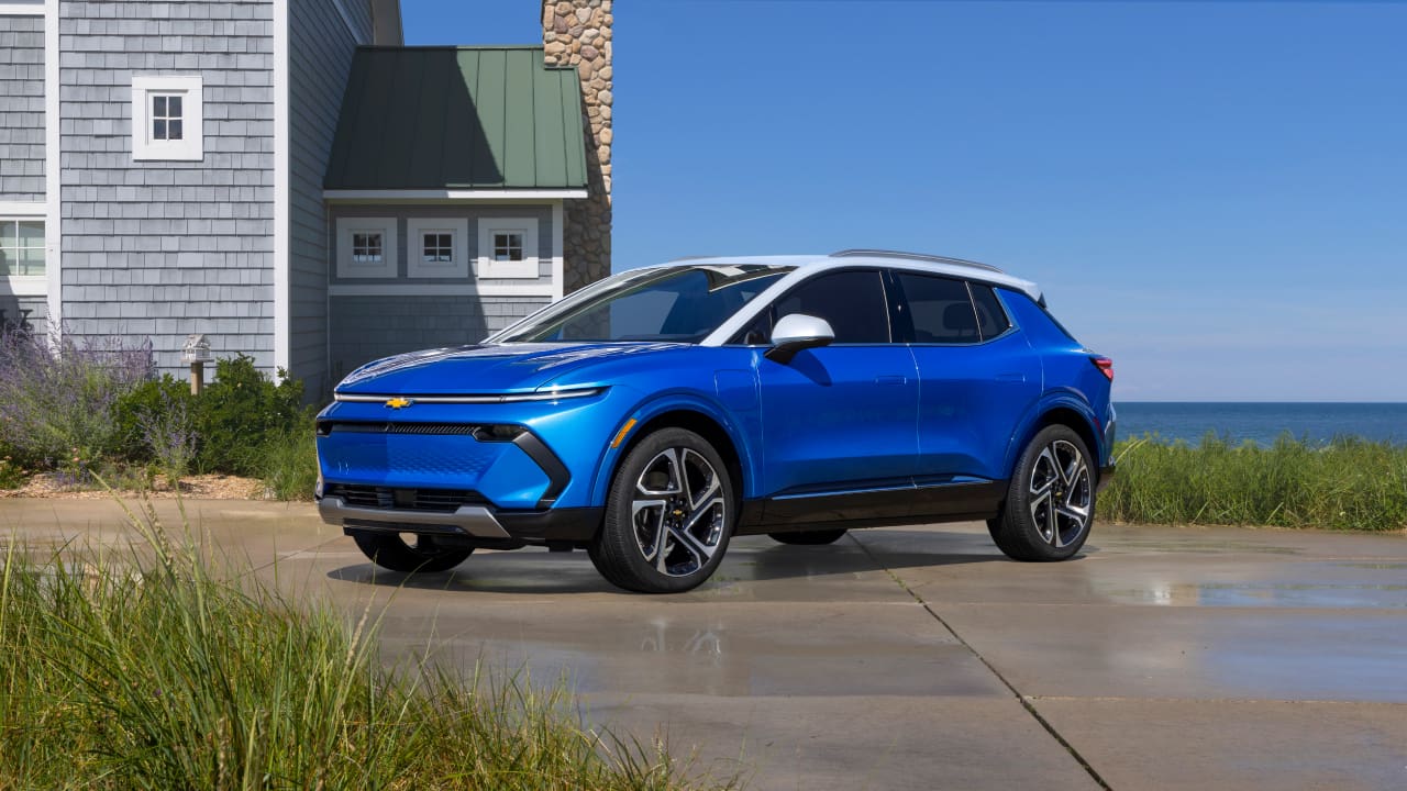 A Chevrolet Equinox EV is parked in front of a house