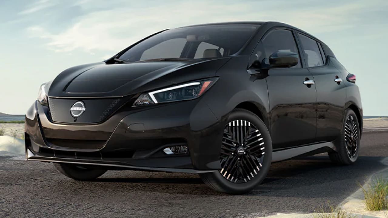 A black Nissan Leaf is parked on the side of the road