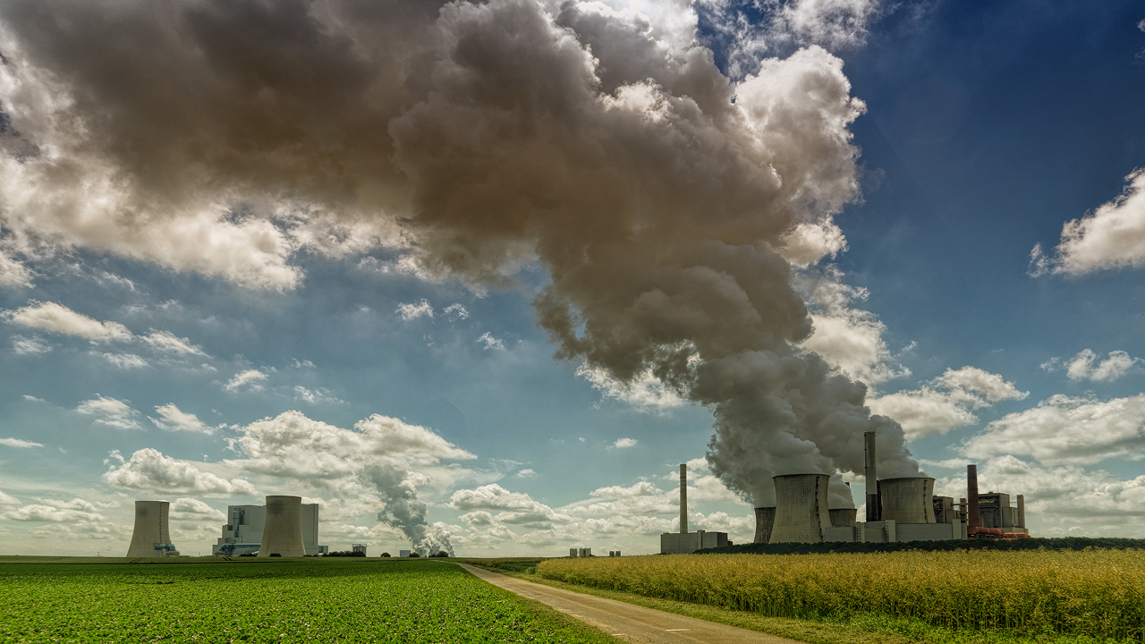 A factory releasing smoke during the day