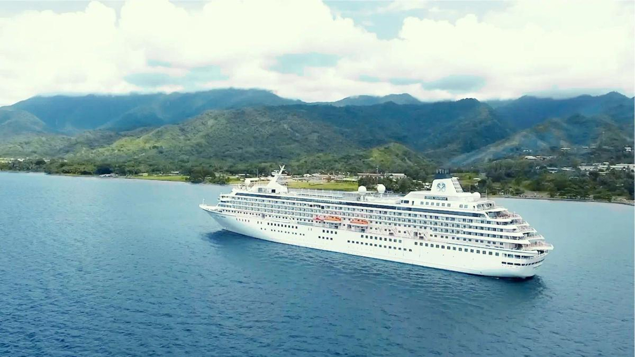 A stunning view of clouds and mountains behind the Crystal cruise ship