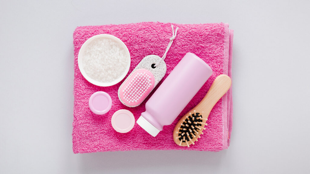 Top view of hair products on pink towel