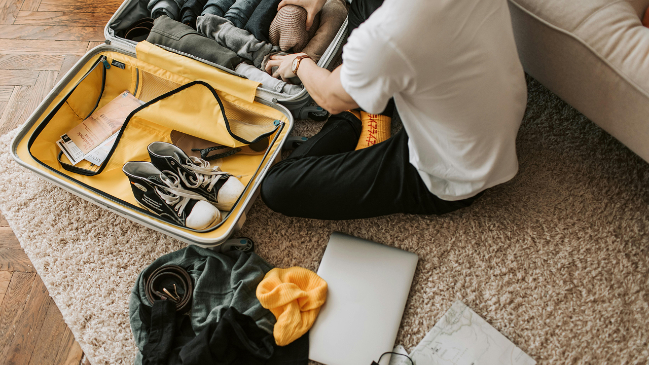 A man packing clothes in his luggage