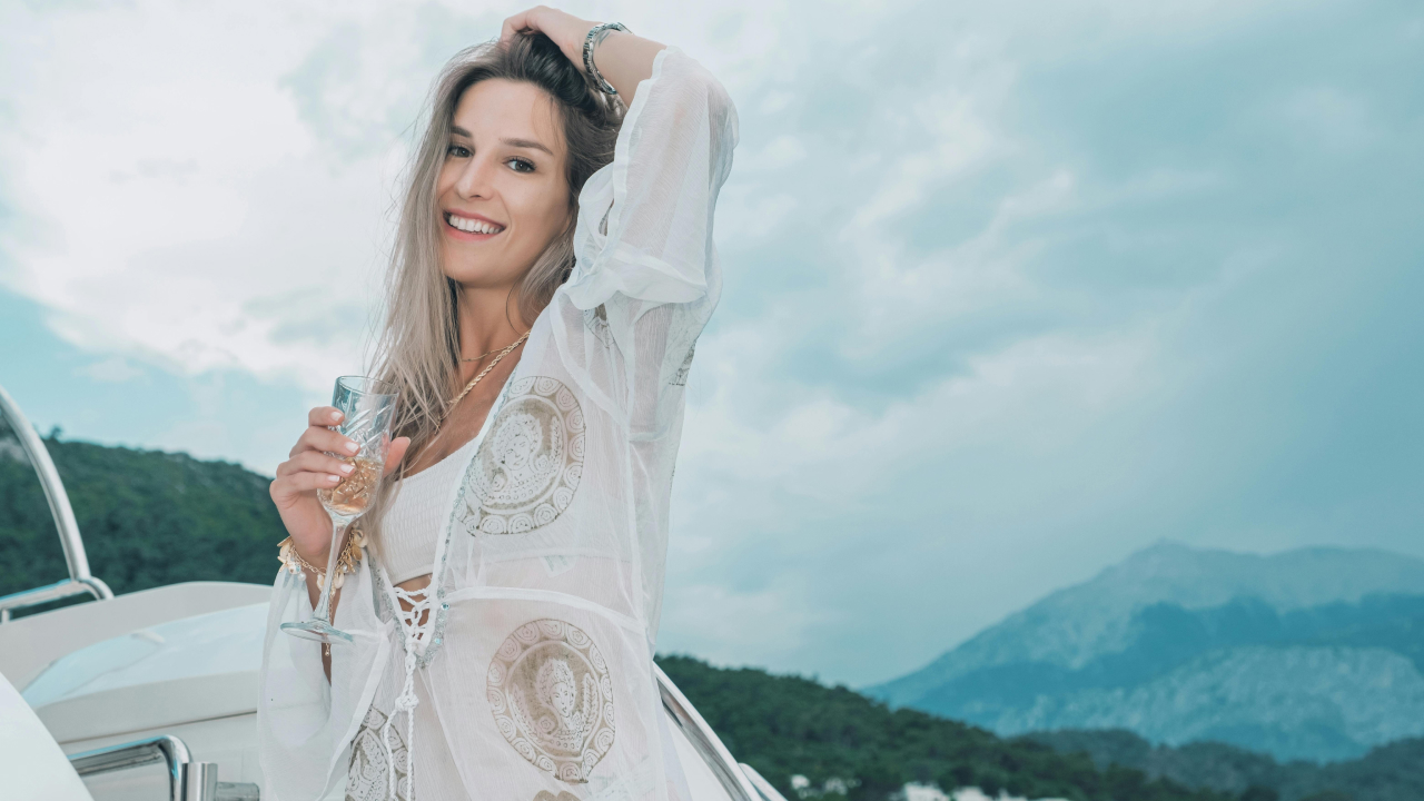 Young woman standing on a cruise with a glass