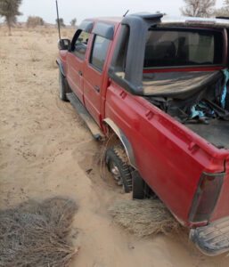 A red 4x4 truck car drenched in cholistan desert sand