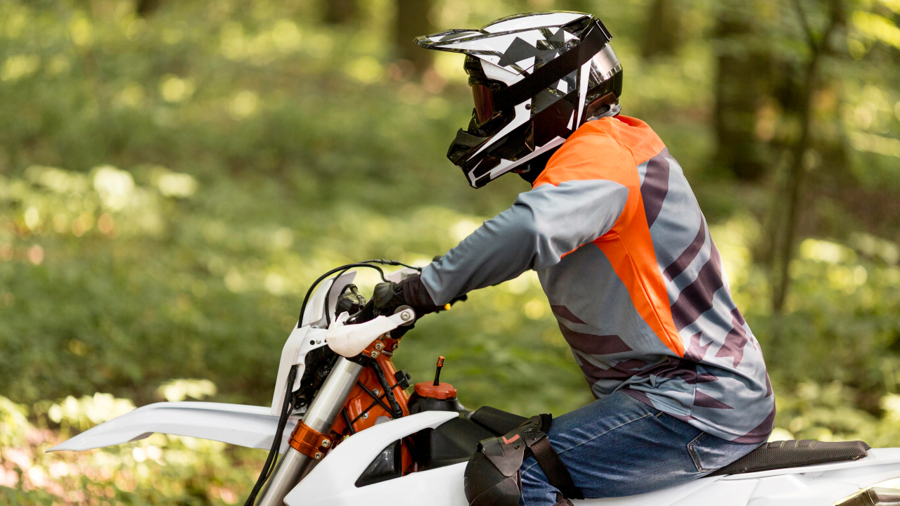 Side view of a man riding electric motocross bike