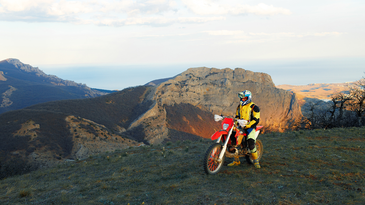 A man riding a motorcross bike in mountains