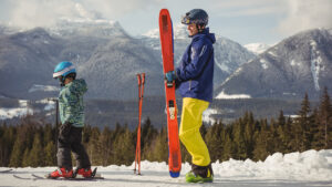 A man and his child skiing together