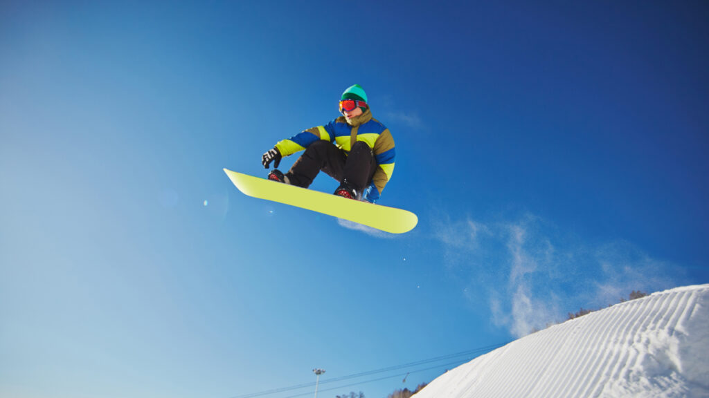 A man performing stunts on a snowboard