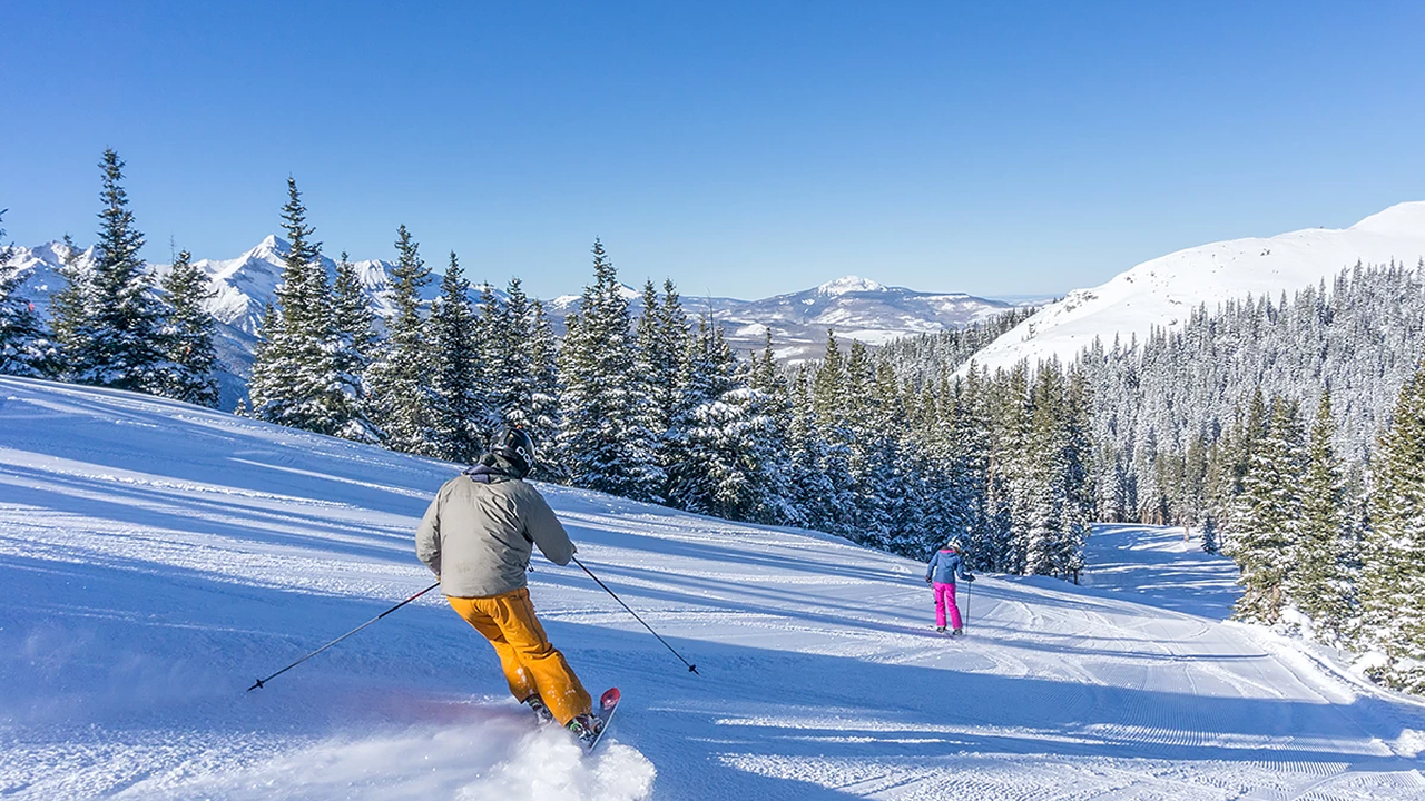 Skiers enjoying a sunny day on snow-covered mountain