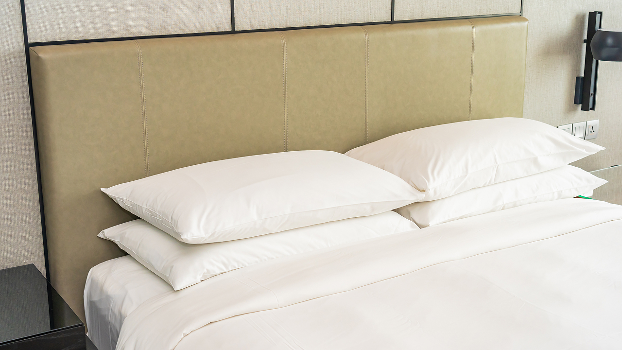 Neatly made bed with white pillows and bedding