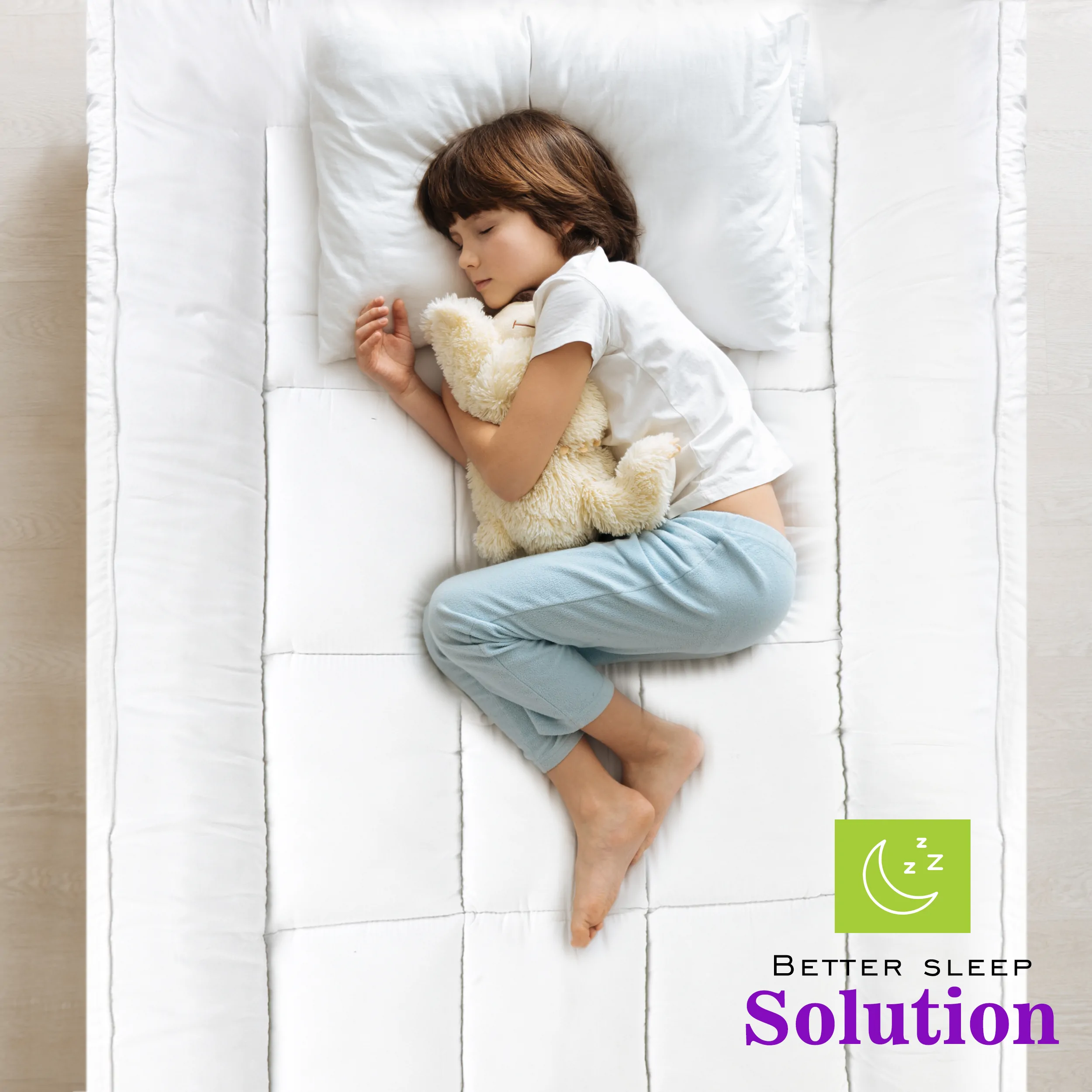 A child sleeping peacefully on a white quilted mattress topper