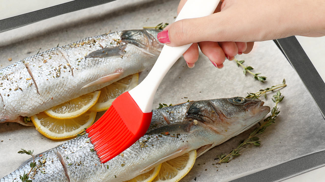 A woman greasing oil on a fish