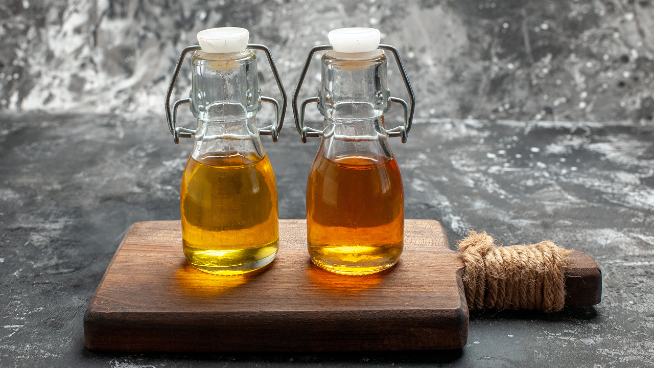 A close-up of two oil bottles on a cutting board