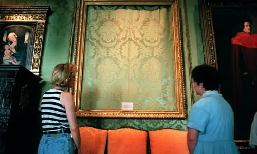 Two people are in a museum, looking at a painting
