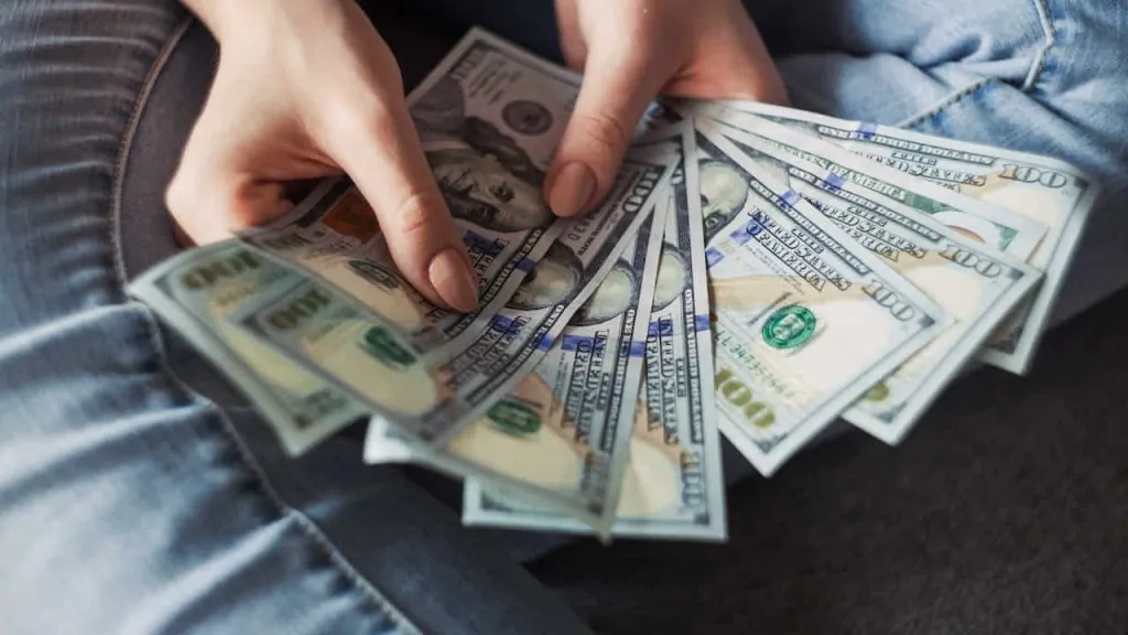 person holding dollar bank notes