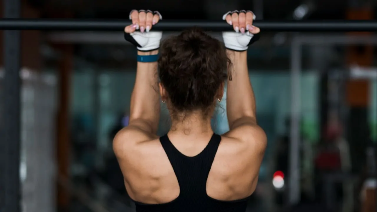 Back view of a women performing pull-ups