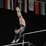 a girl is realizing and grasping on the high gymnastic bars