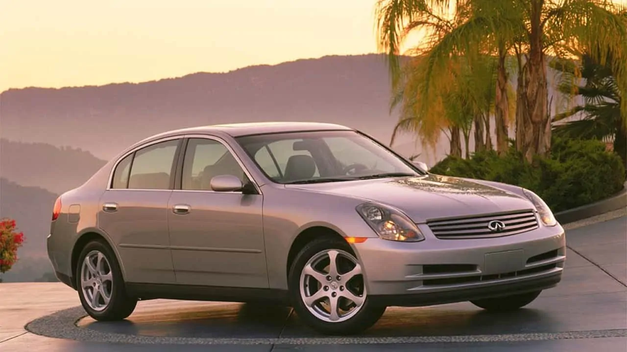 Mountainous background and infiniti G35 going towards the upper direction