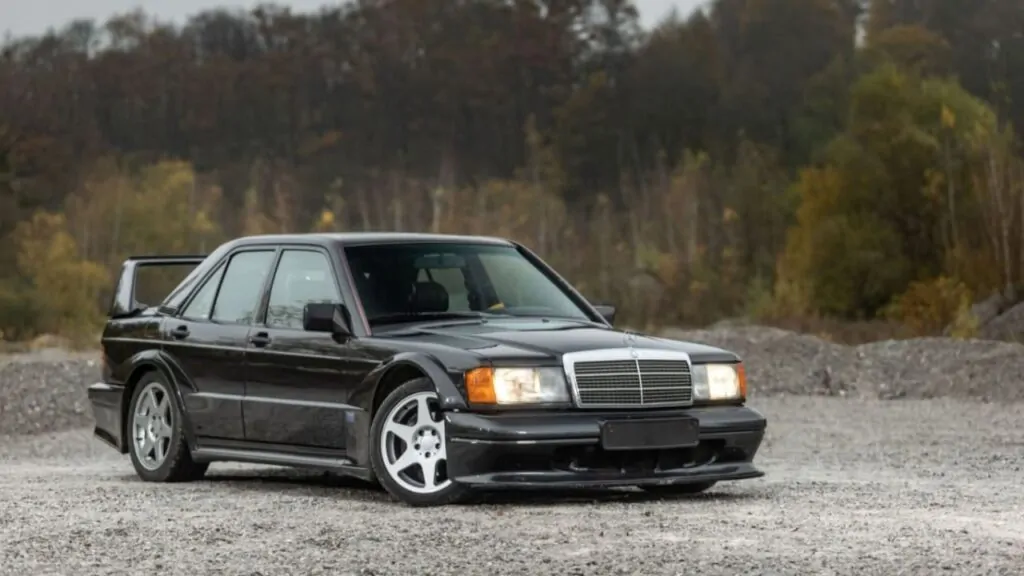 A black Mercedes 190E standing on a muddy surface