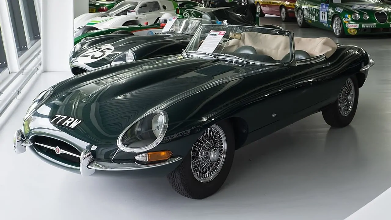 Jaguar E-Type displayed in a showroom along with other cars