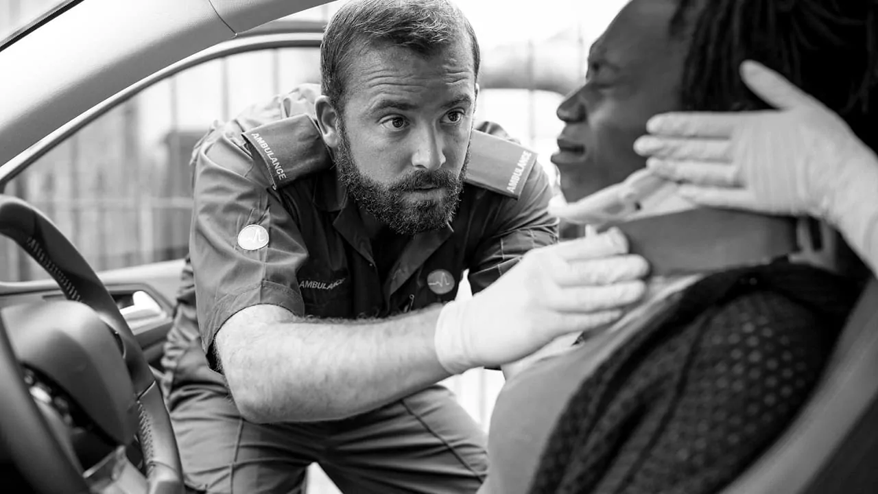 A man is placing a collar on an injured woman.