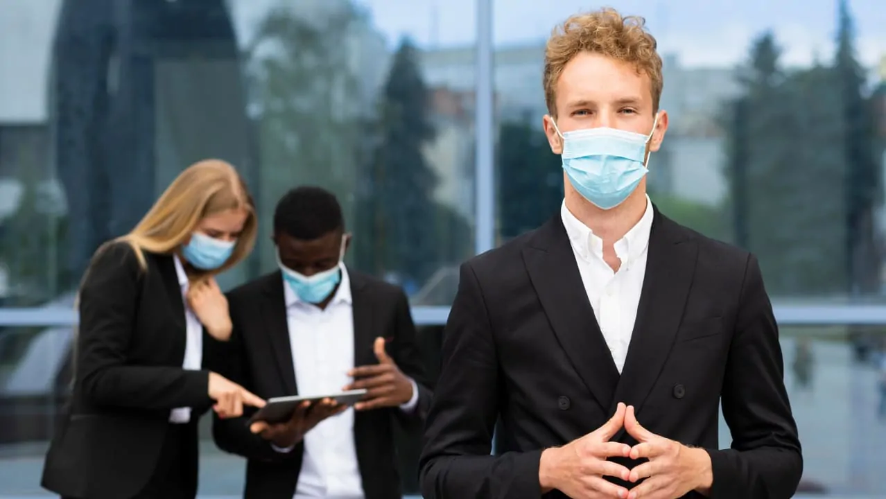 A front view of three people wearing masks and standing